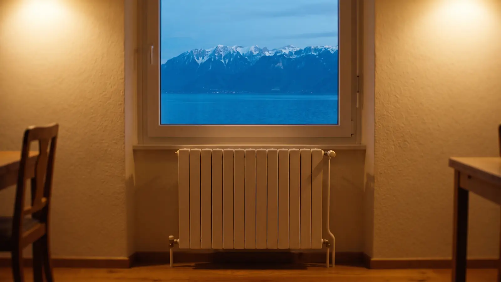 Radiateur moderne sous une grande fenêtre avec vue sur le lac Léman